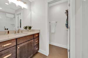 Bathroom featuring vanity, tile patterned floors, a shower, and baseboards