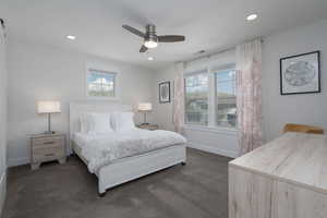 Bedroom with dark colored carpet, baseboards, recessed lighting, and ceiling fan