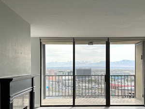 Unfurnished living room with carpet flooring, a fireplace, a wall of windows overlooking the city view