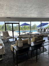 Lobby  area featuring healthy amount of natural light, a textured ceiling, and wood look floors and view to the pool and city.
