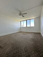 Spacious Primary bedroom featuring ceiling fan , carpet and new paint