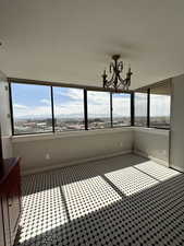 Unfurnished semi-formal sunny dining area featuring a chandelier and healthy amount of natural light