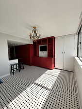 Unfurnished dining area with a chandelier and baseboards