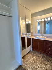 En-suite Full bathroom with  vanity and mirrored storage and closet