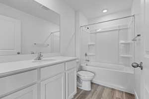 Full bathroom with vanity, bathing tub / shower combination, toilet, and wood finished floors