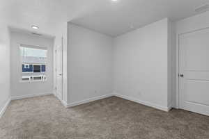 Carpeted spare room with baseboards