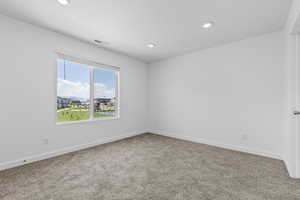 Carpeted empty room with recessed lighting and baseboards