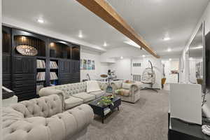 Carpeted living area featuring beamed ceiling, recessed lighting, and a textured ceiling