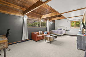 Bedroom featuring wooden ceiling with exposed beams, carpet, and baseboards