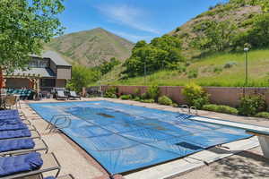 View of pool featuring a mountain view, a diving board, and a patio area