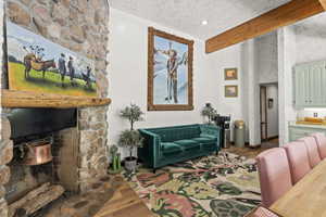 Living room with wood finished floors and a stone fireplace