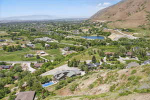Aerial view of property and surrounding area featuring a water and mountain view and nearby suburban area