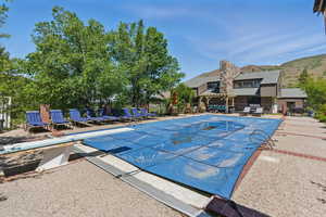 View of pool with a diving board and a patio area
