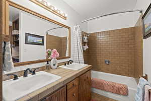 Full bath with shower / tub combo and double vanity