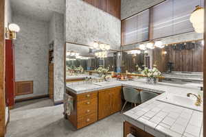 Full bath featuring a high ceiling, double vanity, and a chandelier