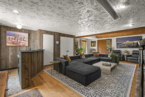 Living room with hardwood / wood-style flooring and wood walls