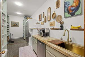 Kitchen featuring dishwasher, a sink, white microwave, and light countertops