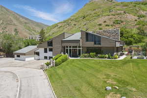 View of front of home with a mountain view and a front yard