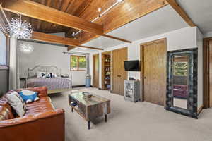 Bedroom with carpet floors, a chandelier, and wood ceiling with exposed beams