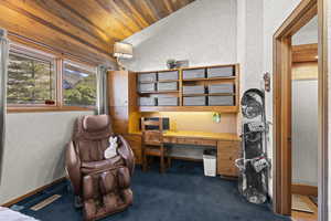 Office featuring a textured wall, wood ceiling, lofted ceiling, and dark colored carpet