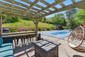 View of swimming pool with a mountain view, a pergola, a patio, and an outdoor fire pit