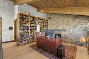 Office area with wooden ceiling with exposed beams and wood finished floors
