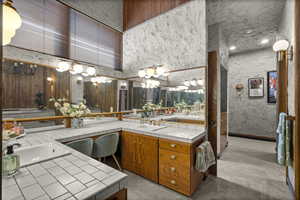 Full bathroom featuring double vanity and a chandelier