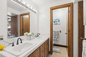 Bathroom featuring toilet, double vanity, and tile patterned floors