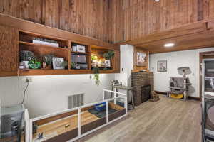Misc room featuring wood finished floors, a fireplace, and wood walls