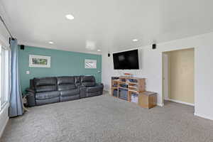 Living room with carpet, recessed lighting, and baseboards