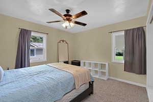 Carpeted bedroom with baseboards and a ceiling fan