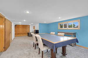 Dining space with light colored carpet and recessed lighting