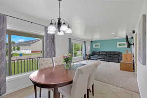 Dining area featuring a chandelier, light tile patterned flooring, recessed lighting, and baseboards