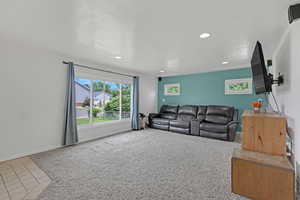 Carpeted living area featuring recessed lighting, tile patterned flooring, and baseboards