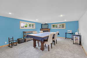 Dining room with light colored carpet, healthy amount of natural light, a fireplace, baseboards, and recessed lighting