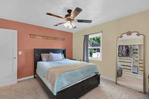 Bedroom featuring light colored carpet, a ceiling fan, and baseboards