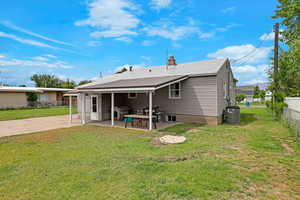 Rear view of house featuring a patio, central AC unit, and a chimney