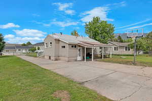 Rear view of property featuring concrete driveway and a chimney