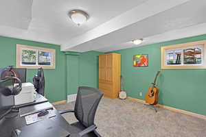 Carpeted office space featuring baseboards