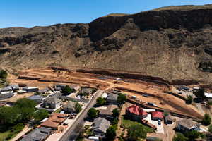 Aerial view of property and surrounding area with a mountain backdrop and nearby suburban area