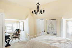 Carpeted bedroom featuring a chandelier, multiple windows, baseboards, and vaulted ceiling