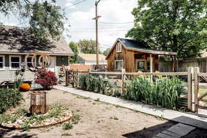 Fenced yard featuring an outdoor structure and a gate