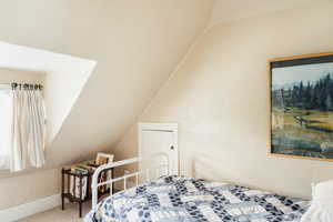 Carpeted bedroom with lofted ceiling