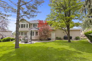 Back of house featuring a patio, stucco siding, and a yard