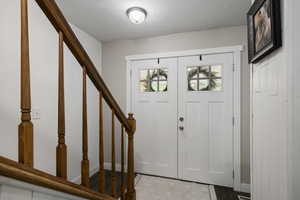 Entryway featuring baseboards and stairs