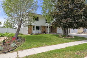 View of front of house with brick siding, driveway, and a garage
