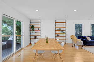 Dining Room with Custom Shelving and Access to Deck