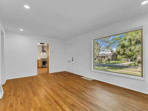 Unfurnished living room with wood finished floors, recessed lighting, and baseboards
