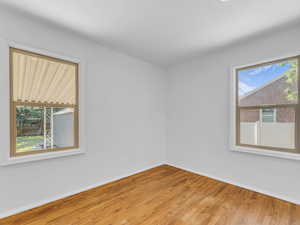 Spare room featuring baseboards and wood finished floors