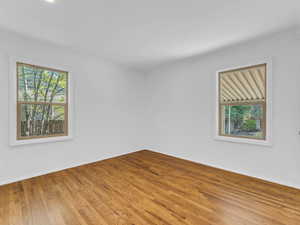Unfurnished room featuring wood finished floors, baseboards, and crown molding